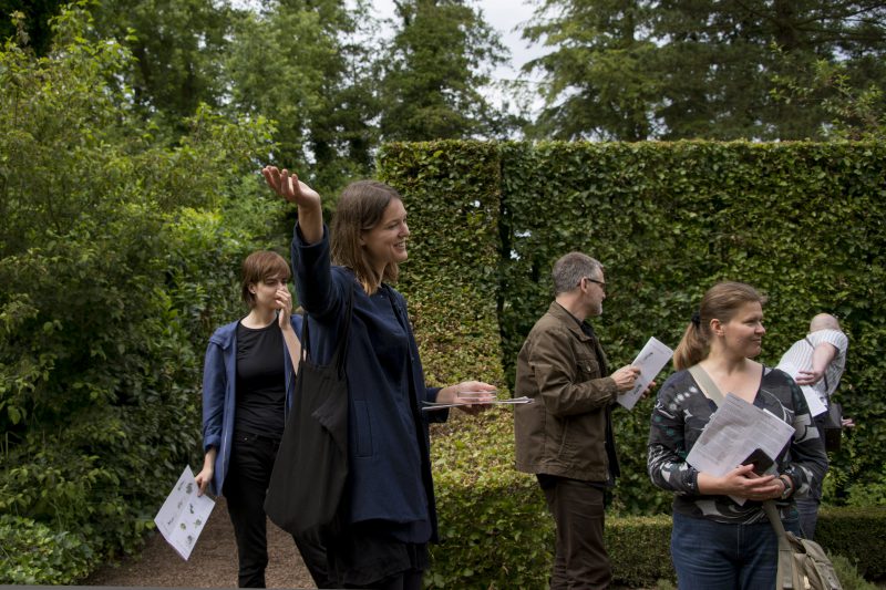 A guide walks her group through the gardens of the estate